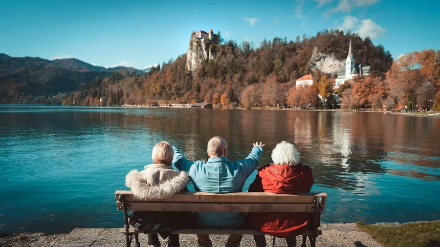 troje seniorów na tle jeziora i lasu